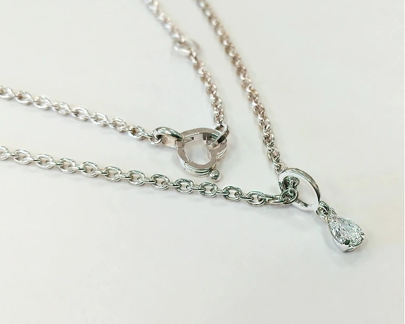 Vedhænget med diamant på 0,8 ct og den håndlavede ankerkæde i hvidguld med hjertelås og tre justeringsringe.