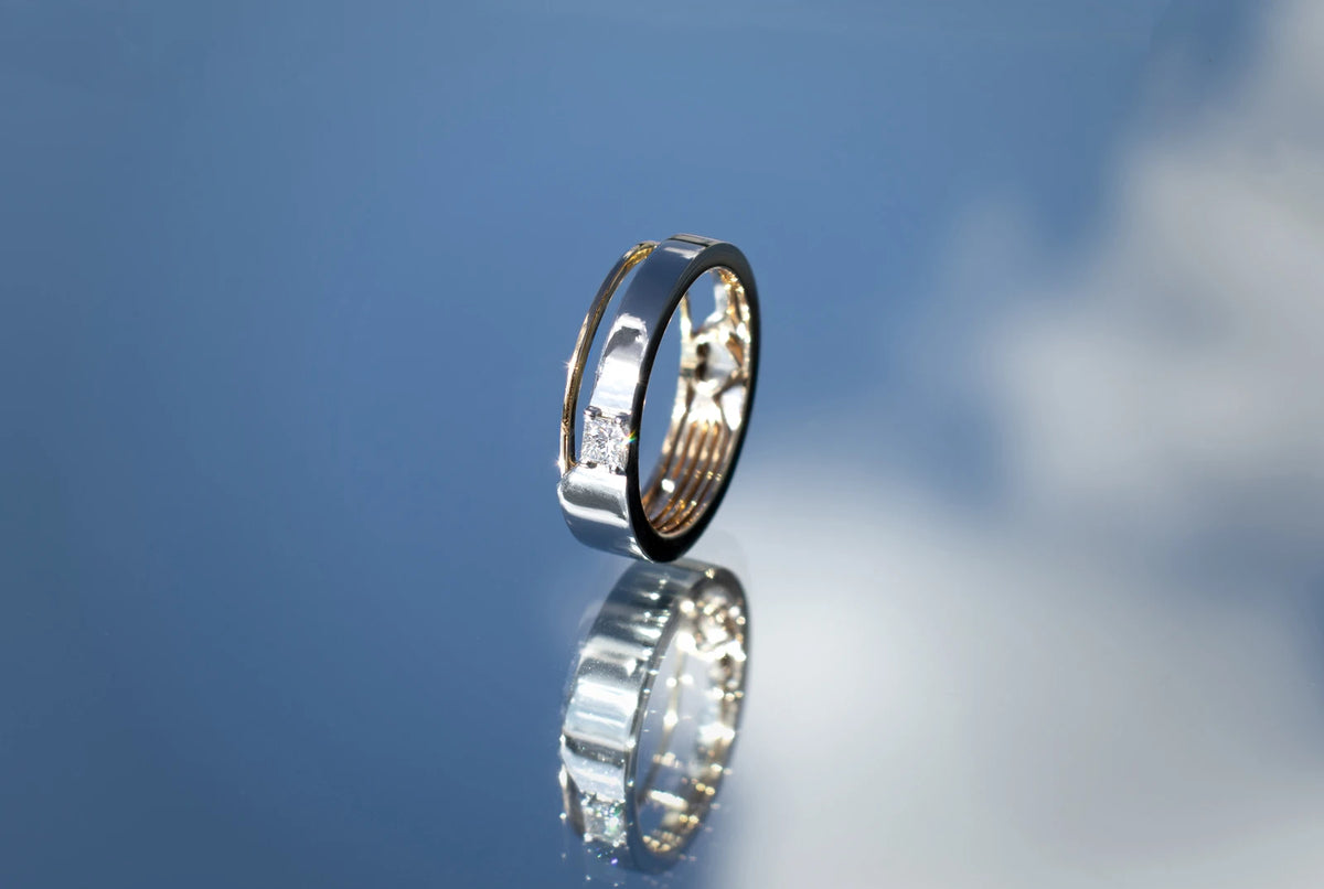 Forlovelsesring og vielsesring med fire personlige linjer — Hvidguld udenpå og gult guld indeni, med en prinsessesleben diamant.